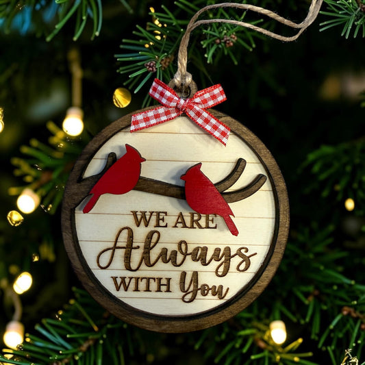 Two-cardinal wooden memorial ornament reading We Are Always With You on a Christmas tree