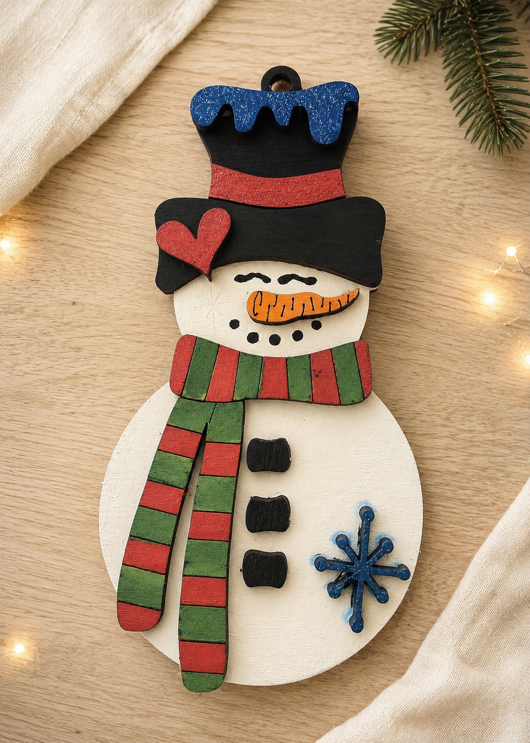 Painted wooden snowman ornament with top hat and striped scarf – finished example